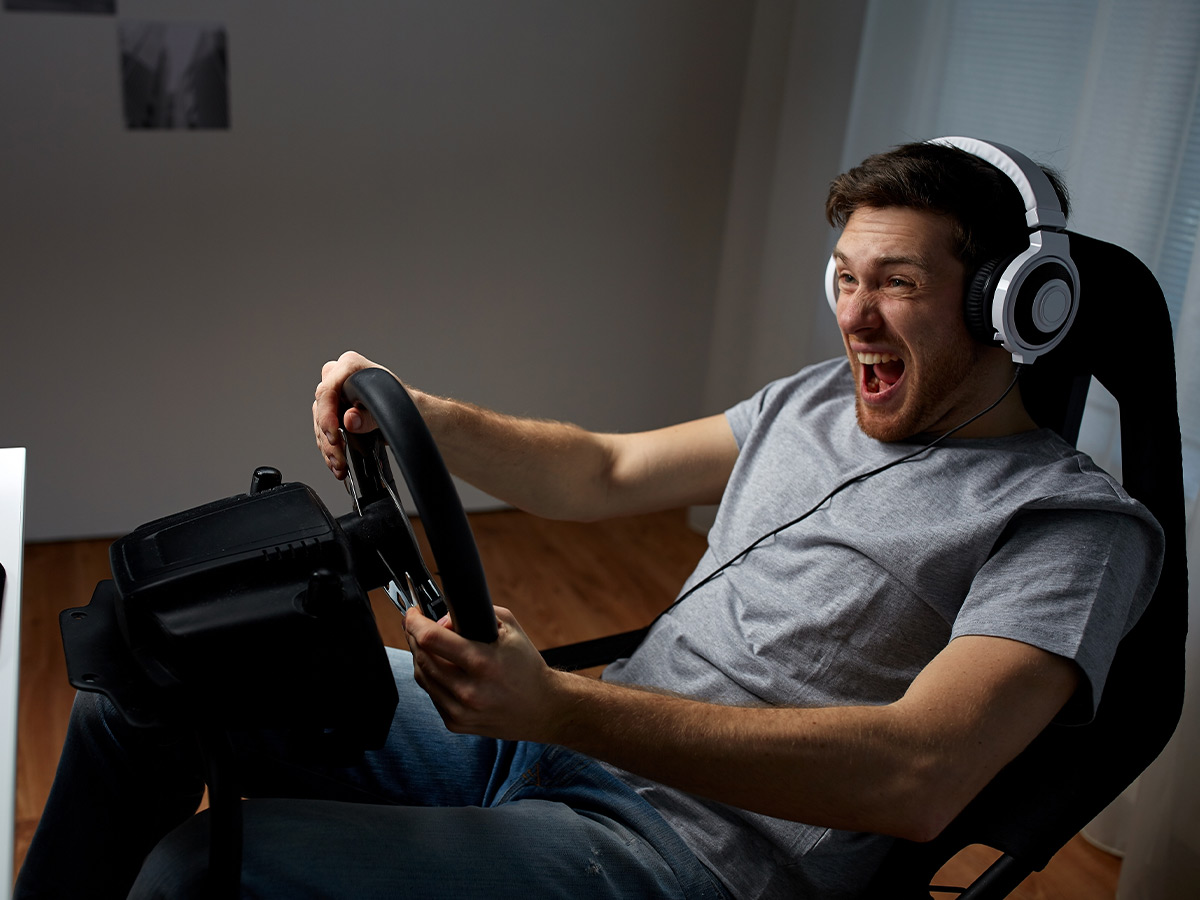 Image of a man sitting in a gaming chair playing a sim racing game