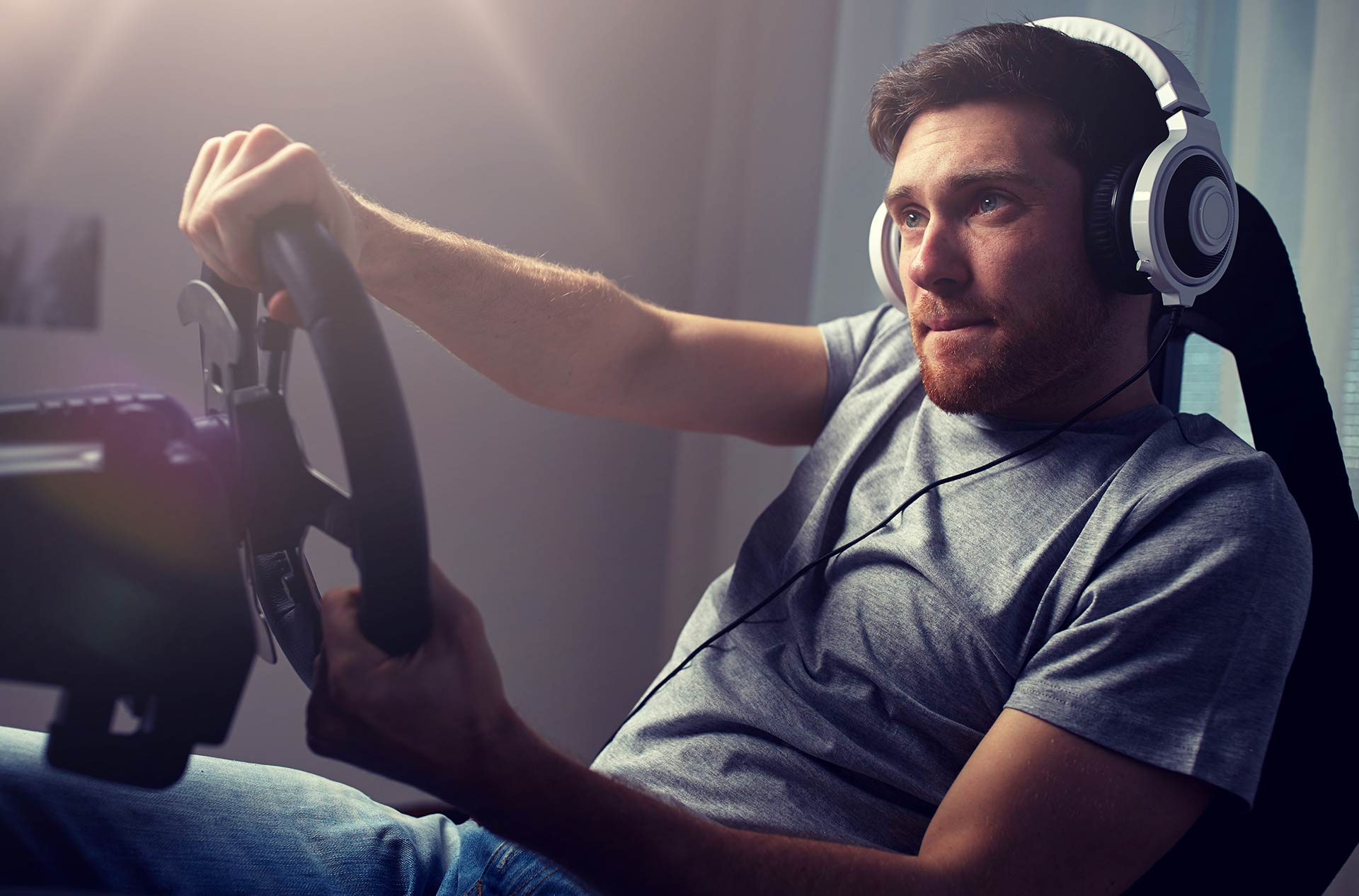 Image of a man wearing a headset and playing a racing sim game